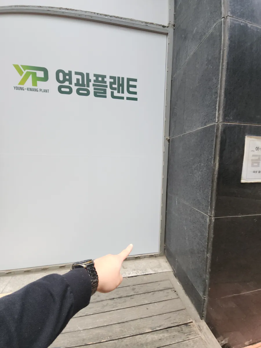 유리에서 원형으로 잘라낸 조각을 손으로 들고 있는 타공 작업 장면