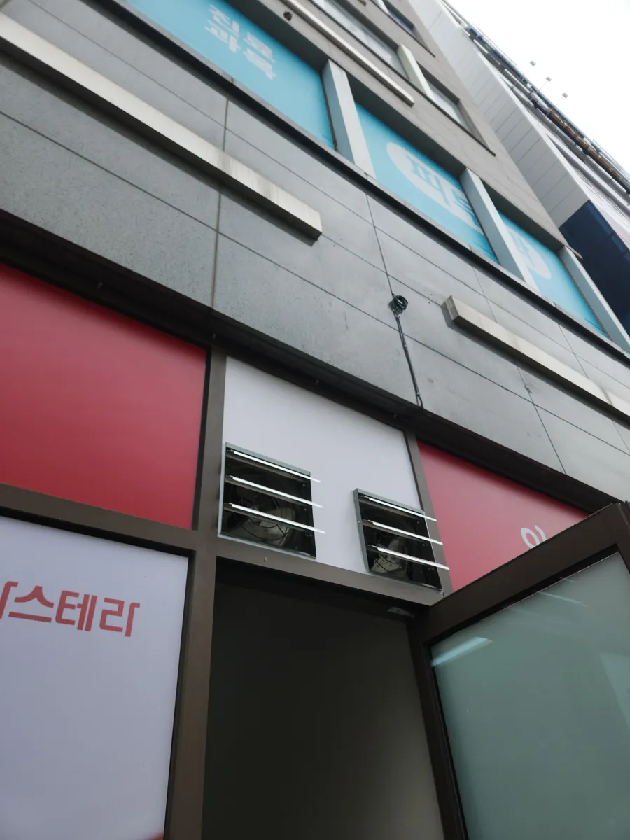 건물 외벽에 환기용 격자가 보이는 창고형 건물의 측면
