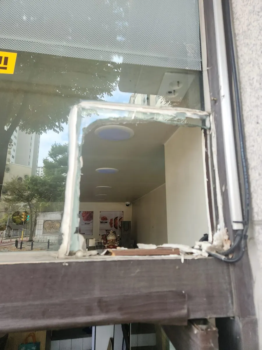 환풍기를 떼어낸 뒤 사각형으로 열려 있는 창 프레임과 남은 실리콘 자국